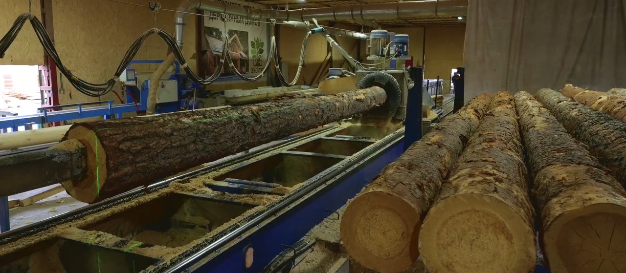 Бревно в токарно-роторном станке цеха оцилиндровки ЭКО-ТЕХ, рядом — бревна, подобранные по диаметру